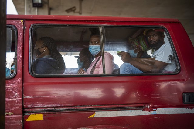 Passengers, some wearing masks, wait for their taxi to leave the Baragwanath taxi rank in Soweto, South Africa, Thursday December 2, 2021. South Africa launched an accelerated vaccination campaign to combat a dramatic rise in confirmed cases of COVID-19 a week after the omicron variant was detected in the country. (Photo by Jerome Delay/AP Photo)