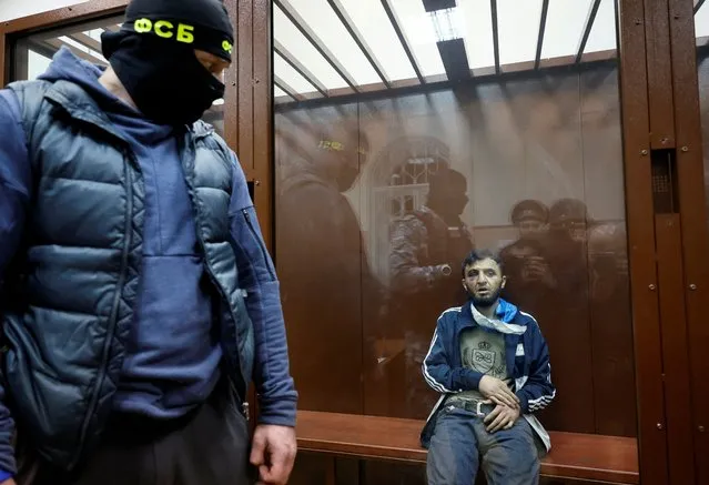 Dalerdzhon Mirzoyev, a suspect in the shooting attack at the Crocus City Hall concert venue, sits behind a glass wall of an enclosure for defendants at the Basmanny district court in Moscow, Russia on March 24, 2024. (Photo by Shamil Zhumatov/Reuters)