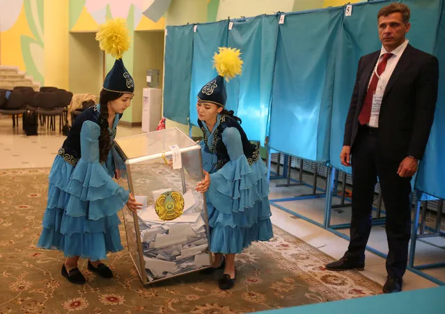 Members of a local election committee carry a ballot box before counting votes during the presidential election in Almaty, Kazakhstan, June 9, 2019. (Photo by Pavel Mikheyev/Reuters)