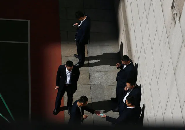 Security officers smoke in the inner courtyard of the Great Hall of the People during the National People's Congress in Beijing, China, March 7, 2017. (Photo by Thomas Peter/Reuters)