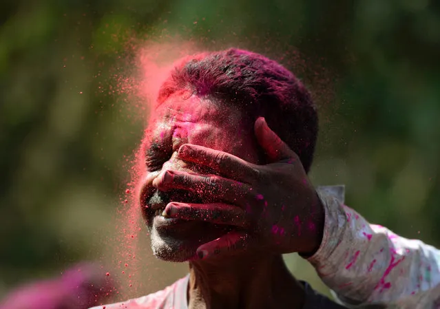 An Indian man is smeared with coloured powder during the Holi celebrations in Mumbai on March 13, 2017. (Photo by Punit Paranjpe/AFP Photo)