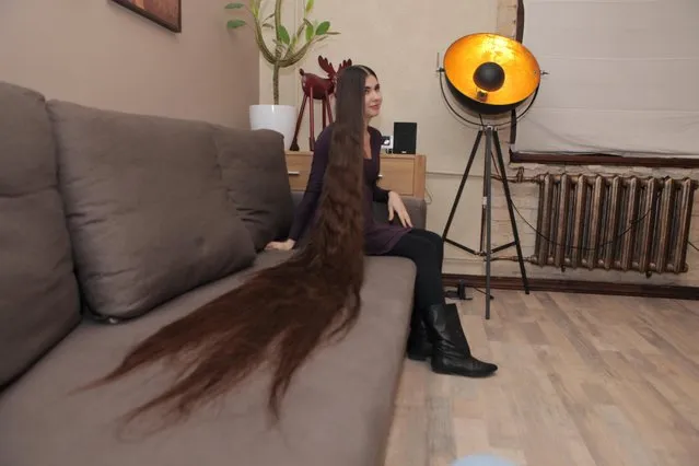 Aliia Nasyrova laying her hair on the couch to show her hair's length on March 5, 2017 in Riga, Latvia. Real-life Rapunzel Aliia Nasyrova has hair so long that her husband admits he thinks of it as another member of the family. Aliia, 27, who lives in Riga, Latvia, took 20 years to grow out her hair, which measures 90 inches to the floor – and even has its own space in the marital bed. And while her massive mane attracts stares when out in public, her husband Ivan Balaban says he loves it and is proud of her for not cutting it. Weighing in at 4.5lbs (2kg), Aliia says her lengthy locks weigh as much as the family cat. (Photo by  Eduard Kolik/Barcroft Media)