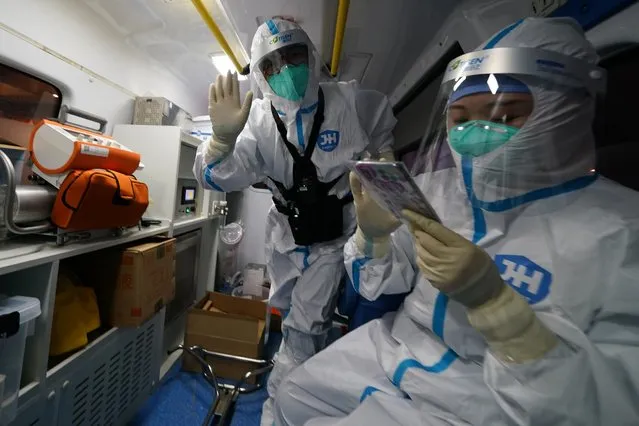 A medical worker waves while transporting Associated Press photographer Matt Slocum after a positive coronavirus test at the 2022 Winter Olympics, Wednesday, February 9, 2022, in Beijing. Slocum was monitored for hours before testing negative and being cleared to go back to work. (Photo by Matt Slocum/AP Photo)