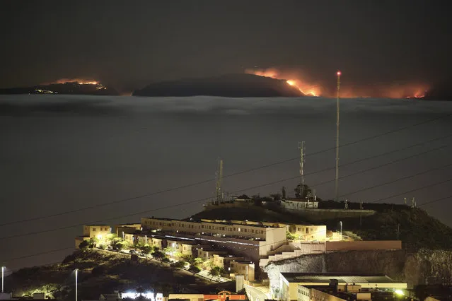 The fire on the mountains of the Canary Islands in this view taken from Santa Cruz de Tenerife island, Spain, early Monday, August 19, 2019. Authorities on Spain's Canary Islands say around 4,000 people have been evacuated due to a wildfire that has ravaged more than 1,700 hectares (4,200 acres) since it broke out a day ago. (Photo by Andres Gutierrez/AP Photo)
