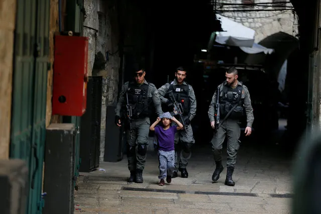 Israeli border policemen escort a boy away from a blocked alley after a stabbing attack inside the old city of Jerusalem according to Israeli police, April 1, 2017. The boy is not involved in the incident. (Photo by Ammar Awad/Reuters)