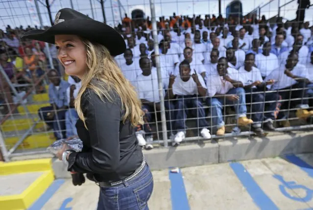 Miss Rodeo Louisiana Hannah Bergeron walks past the inmate section at the Angola Prison Rodeo in Angola, La., Saturday, April 26, 2014. In a half-century, the event has grown from a small event for prisoners into a big business that draws thousands of spectators to the Louisiana State Penitentiary. (Photo by Gerald Herbert/AP Photo)