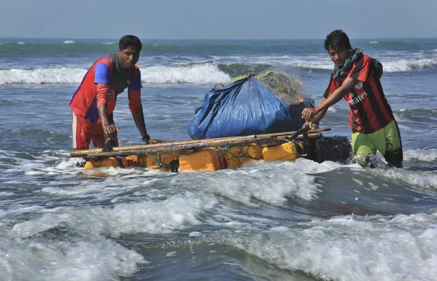 In this January 16, 2017, photo, Rohingya fishermen pull their raft made of empty plastic containers along the coastline of the Bay of Bengal in Tha Pyay Taw village, Maungdaw, western Rakhine state, Myanmar. Their usual, sturdy fishing boats were outlawed three months ago when Myanmar authorities launched a sweeping and violent counter-insurgency campaign in Rakhine state, home to the long-persecuted Rohingya Muslim minority. The ban on fishing boats – meant to prevent insurgents from entering or leaving the country by sea – is just one small provision in the wider crackdown, in which authorities have been accused of widespread abuses. (Photo by Esther Htusan/AP Photo)