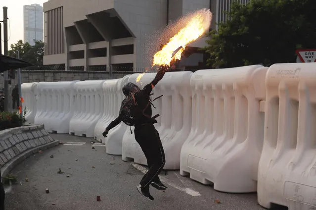 An anti-government protester throws a Molotov cocktail during a demonstration near Central Government Complex in Hong Kong, Sunday, September 15, 2019. (Photo by Kin Cheung/AP Photo)