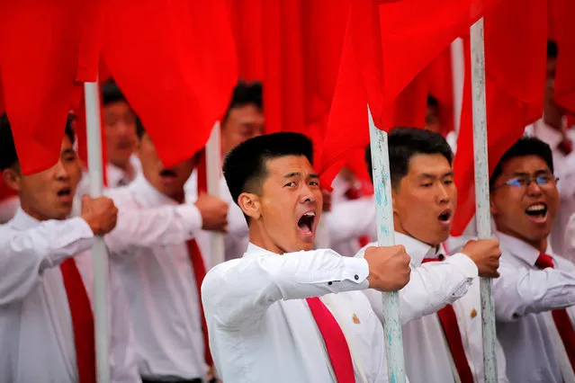Students carrying party flags shout slogans as they march past North Korean leader Kim Jong Un during a mass rally and parade in the capital's main ceremonial square, a day after the ruling party wrapped up its first congress in 36 years by elevating him to party chairman, in Pyongyang, North Korea, May 10, 2016. (Photo by Damir Sagolj/Reuters)