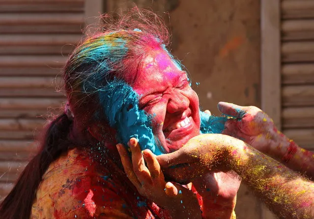 A woman reacts as coloured powder is applied on her face during Holi celebrations in Kolkata, India, March 18, 2022. (Photo by Rupak De Chowdhuri/Reuters)