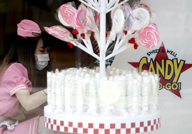 A shop clerk prepares to open a candy store at Harajuku shopping district in Tokyo, Japan, April 30, 2015. (Photo by Yuya Shino/Reuters)