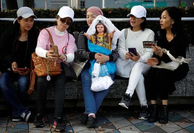Filipino women watch a live stream of Pope Francis' Holy Mass outside the Tokyo Dome, in Tokyo, Japan, November 25, 2019. (Photo by Kim Kyung-Hoon/Reuters)
