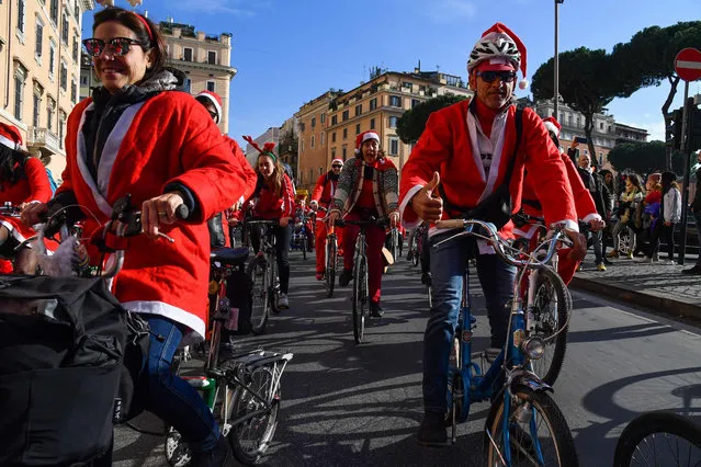 People dressed as Santa Claus take part in a Santa Claus Christmas charity ride for the association The Houses of Peter Pan, on december 15, 2019 through Largo di Torre Argentina in downtown Rome. Peter Pan's Houses encourages sharing, socialization and mutual support between families. (Photo by Andreas Solaro/AFP Photo)