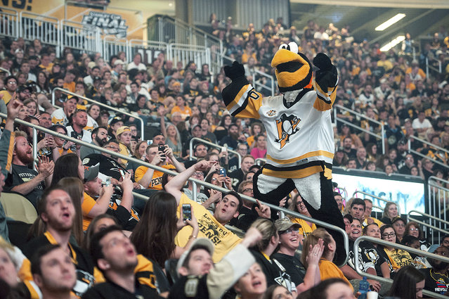 Iceburgh, mascot of the Pittsburgh Pengunis, gestures to fans watching television coverage of the Penguins playing the Nashville Predators in Game 6 of the Stanley Cup final Sunday, June 11, 2017, during a watch party at PPG Paints Arena in Pittsburgh. (Photo by Stephanie Strasburg/Pittsburgh Post-Gazette via AP Photo)