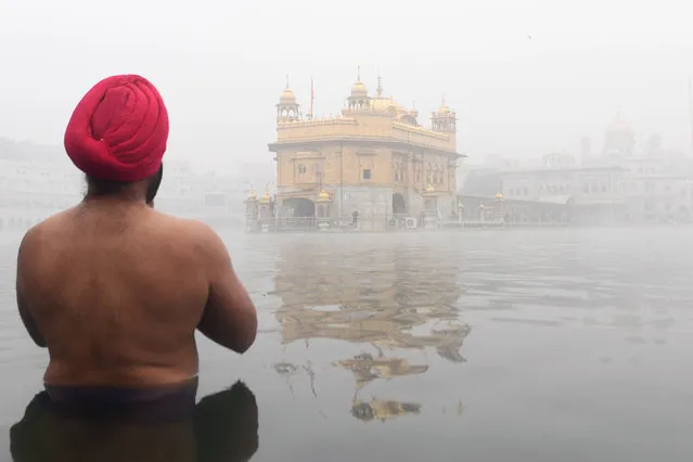 A devotee prays at the Sikh shrine the Golden Temple amid dense fog conditions in Amritsar on December 18, 2019. (Photo by Narinder Nanu/AFP Photo)