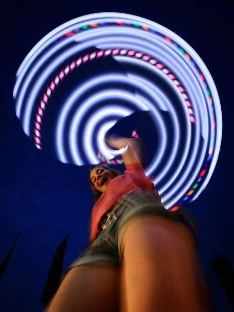 A girl uses a glowing hula hoop, as revelers gather ahead of this weekends Glastonbury Festival of Music and Performing Arts on Worthy Farm in Somerset. (Photo by Leon Neal/AFP Photo)