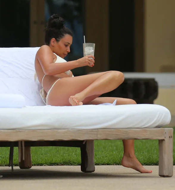 A bikini clad Kim Kardashian cools off with an icy drink while on vacation in Mexico. (Photo by Brian Prahl/Splash News)