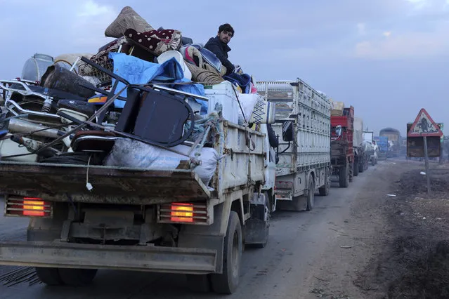 A man rides in a truck as civilians flee a Syrian military offensive in Idlib province on the main road near Hazano, Syria, Tuesday, December 24, 2019. Syrian forces launched a wide ground offensive last week into the northwestern province of Idlib, which is dominated by al-Qaida-linked militants. The United Nations estimates that some 60,000 people have fled from the area, heading south, after the bombings intensified earlier this month. (Photo by Ghaith al-Sayed/AP Photo)