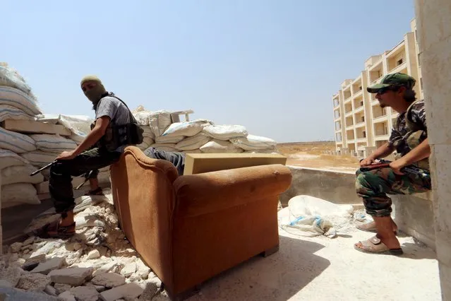 Nusra Front fighters rest with their weapons behind sandbags in the Sheikh Maksoud neighborhood of Aleppo, Syria August 3, 2015. (Photo by Abdalrhman Ismail/Reuters)