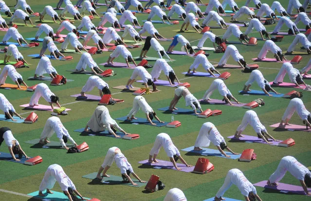 Nearly a thousand people practice yoga together during a local event promoting healthy lifestyle, in Taiyuan, Shanxi Province, China, June 15, 2016. (Photo by Reuters/Stringer)
