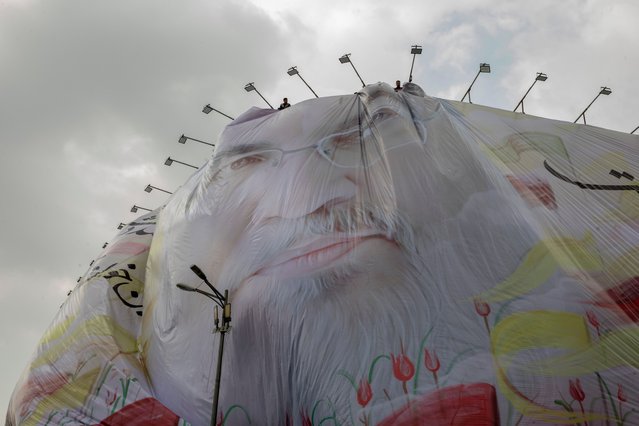 Workers are installing a big banner depicting Hassan Nasrallah, the slain leader of Lebanon's Hezbollah, in central Tehran, two days after his targeted assassination by Israeli forces in the southern suburbs of Beirut, on September 29, 2024 in Tehran, Iran. Iran's Supreme Leader vowed that Israel's killing of Hassan Nasrallah, the longtime leader of the Iran-backed Lebanese militant group Hezbollah, would be avenged. Iran declared five days of mourning after confirmation of his death in an airstrike on Beirut on Sept. 27. (Photo by Majid Saeedi/Getty Images)