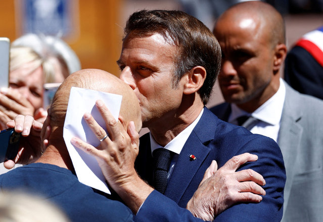 French President Emmanuel Macron kisses a person as he arrives to vote in the first round of French parliamentary elections, at a polling station in Le Touquet-Paris-Plage, France on June 12, 2022. (Photo by Yves Herman/Reuters)