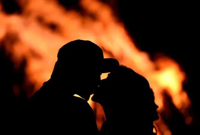 A couple kissing in front of bonfire during the traditional San Juan's (Saint John) night in Gijon, northern Spain, June 24, 2016. (Photo by Eloy Alonso/Reuters)