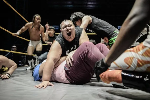 This picture taken on May 21, 2016 shows professional wrestlers fighting each other during the Wrestling City Asia organized by Singapore Pro Wrestling at a stadium in Kuala Lumpur. Kenneth Thexeira is a mild-mannered writer for an interior-design magazine by day, but on certain nights his alter ego bursts forth in golden tights and a baby-blue cape: enter “The Eurasian Dragon”. (Photo by Mohd Rasfan/AFP Photo)