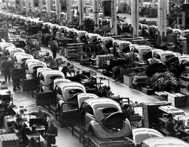 This general view shows the assembly lines at the Volkswagen auto works plant, which manufactures nearly 900 automobiles each day, in Wolfsburg, West Germany, on June 16, 1954. (Photo by AP Photo/Reithausen)