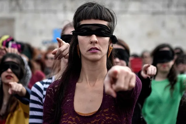 Female activists perform a choreography originated in Chile, and inspired by the Chilean feminist group Las Tesis, to protest against gender violence and patriarchy in front of the Greek parliament at Athens' Syntagma Square on December 22, 2019. (Photo by Louisa Gouliamaki/AFP Photo)