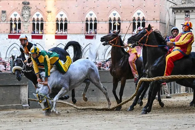 Italian jockey Stefano Piras (2ndL), who races for the “Bruco” district, falls during a false start of his horse “Uragano Rosso” during the historical Italian horse race “Palio di Siena” on July 2, 2022 in Siena, Tuscany. (Photo by Alberto Pizzoli/AFP Photo)