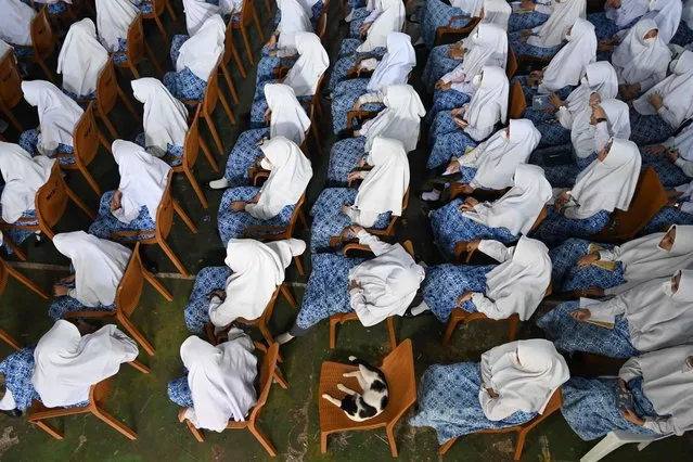Muslim students attend a ceremony during a visit by members of the Nottinghamshire Band of the Royal Engineers at a Muslim boarding school in Jakarta on May 30, 2022, to celebrate Queen Elizabeth II Platinum Jubilee which marks her 70th year on the throne. (Photo by Adek Berry/AFP Photo)