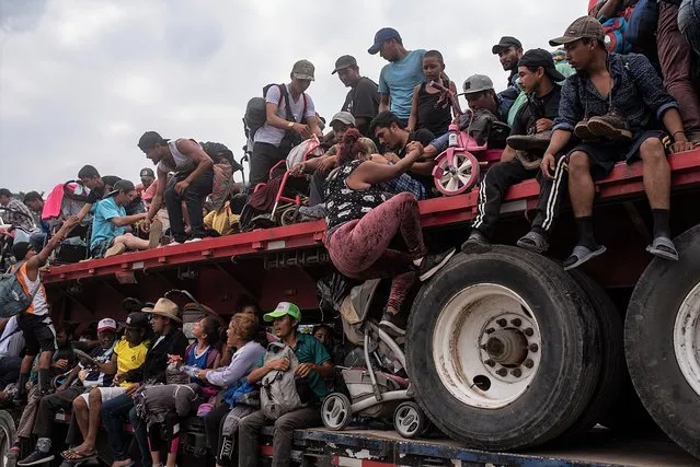 Central American migrants travel in trucks during their caravan to the north, in the municipality of Jesus Carranza, Veracruz state, Mexico, 17 November 2021. The caravan of Central American migrants heading to the United States rested on Wednesday after crossing the border of the western Mexican state of Veracruz at a slower pace, where they are guarded by a strong security device. (Photo by Angel Hernandez/EPA/EFE)