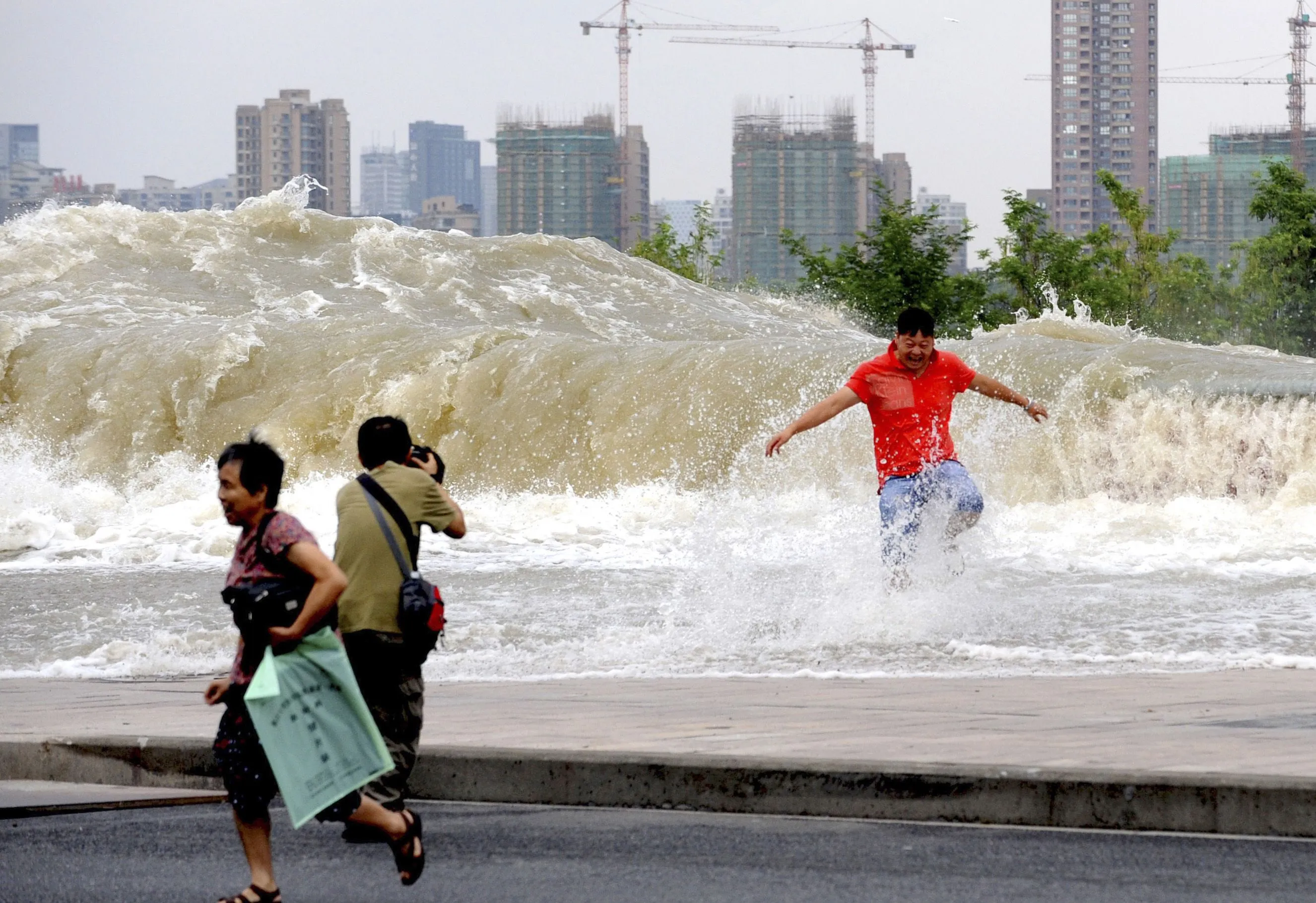 Против течения китай. Цяньтан приливная волна. Приливная волна в Китае. Люди бегут от ЦУНАМИ.