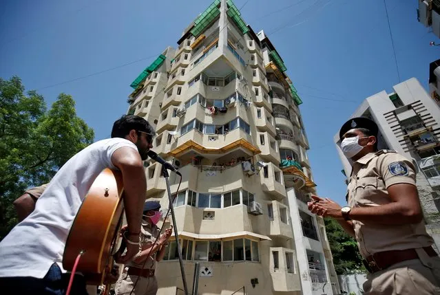 A man performs a song during a programme organized by the police to entertain the residents during a 21-day nationwide lockdown to slow the spreading of the coronavirus disease (COVID-19), in Ahmedabad, India, April 3, 2020. (Photo by Amit Dave/Reuters)