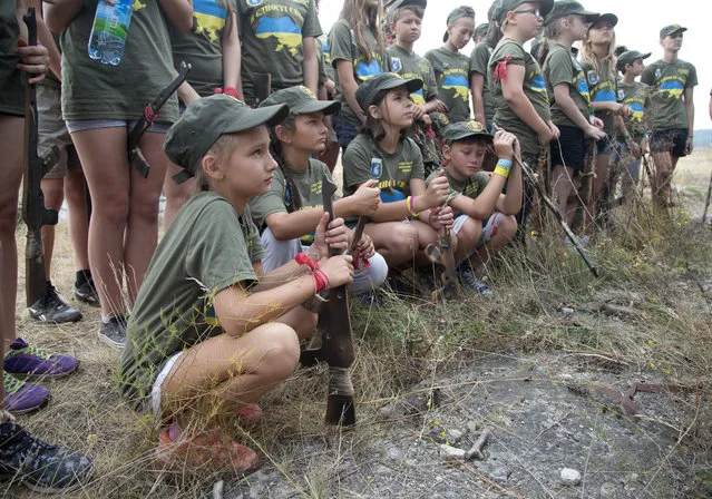 Children listen to instructors at a military training ground of Ukraine's National Guard outside the village of Stare, the Kiev region, Ukraine, Saturday, August 29, 2015. (Photo by Efrem Lukatsky/AP Photo)