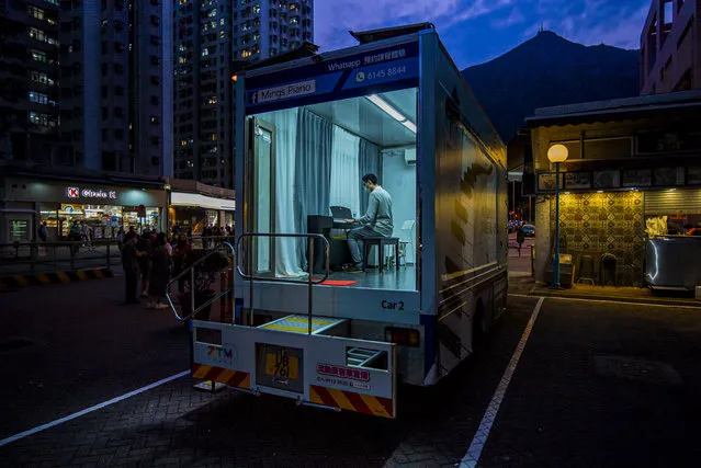 A person plays piano inside a Ming's Piano truck at a car park, on April 10, 2020 in Hong Kong, China. In attempt to keep their business during the COVID-19 pandemic, Ming’s Piano, a music school with 12 teachers and about 200 students, has hired three trucks to deliver lessons at students' doorsteps. (Photo by Billy H.C. Kwok/Getty Images)