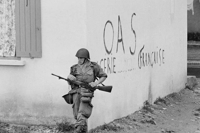 A soldier of the French army is shown in position at the corner of a building in the St. Eugene district of Oran in Algeria, April 28, 1962. Algeria is celebrating 60 years of independence from France on Tuesday July 5, 2022 with nationwide ceremonies, a pardon of 14,000 prisoners and its first military parade in years. Tuesday's events mark 60 years since the official declaration of independence on July 5, 1962, after a brutal seven-year war which ended 132 years of colonial rule. The war, which killed at least 1.5 million people, remains a point of tension in relations between Algeria and France. OAS (Organization of the Secret Army) French dissident graffiti reads “Algeria French”. (Photo by Horst Faas/AP Photo/File)