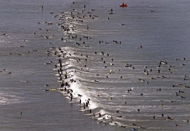 Surfers attempt to break the Guinness World Record for the most surfers on a wave at one time, in Muizenberg on the outskirts of  Cape Town, South Africa, on September 30, 2012. (Photo by Schalk van Zuydam/Associated Press)
