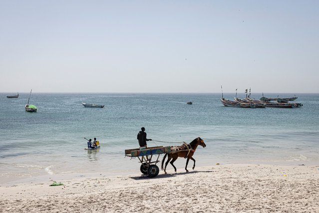 A man drives his horse cart ahead of a memorial ceremony to remember migrants who lost their life at sea on the beach in Mbao, on February 6, 2025. Beaches like the one in Mbao are one of the many departure points for the thousands of Africans who have been taking the perilous Atlantic route for years, attempting to reach Europe mainly via the Spanish Canary Islands, often on overcrowded and outdated boats.Thousands of people have died on this route in recent years, many of them young Senegalese heavily affected by unemployment in search for a better future for them and their families. (Photo by Patrick Meinhardt/AFP Photo)