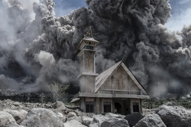 Ash from Mount Sinabung volcano fills the sky over an abandoned church during another eruption in Karo, in Indonesia's North Sumatra province on June 19, 2015. Sinabung rumbled back to life in 2013 after a period of inactivity, since when around 10,000 people have had to evacuate their homes. (Photo by Sutanta Aditya/AFP Photo)
