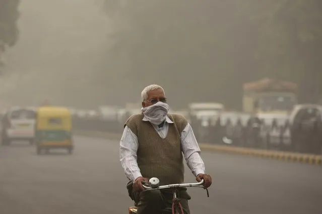 A cyclist covers his face amid heavy smog, on November 8, 2017 in New Delhi, India. Delhi was enveloped in a thick blanket of haze for the second consecutive day with air quality levels deteriorating. Deputy chief minister Manish Sisodia says all schools to remain shut till Sunday. (Photo by Burhaan Kinu/Hindustan Times via Getty Images)
