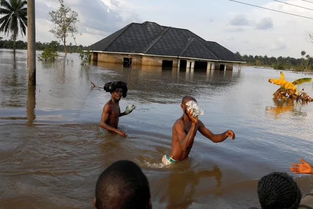 Residents wade through flood water following a massive flood in Obagi community, Rivers state, Nigeria on October 22, 2022. (Photo by Temilade Adelaja/Reuters)
