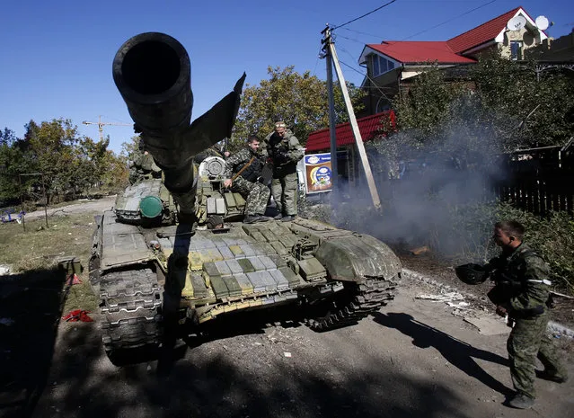 An pro-Russian rebel tank rolls to take position near to airport in the town of Donetsk, eastern Ukraine, Friday, October 3, 2014. Pro-Russian rebels are pressing to seize a key airport in eastern Ukraine despite fierce resistance by government forces. (Photo by Darko Vojinovic/AP Photo)