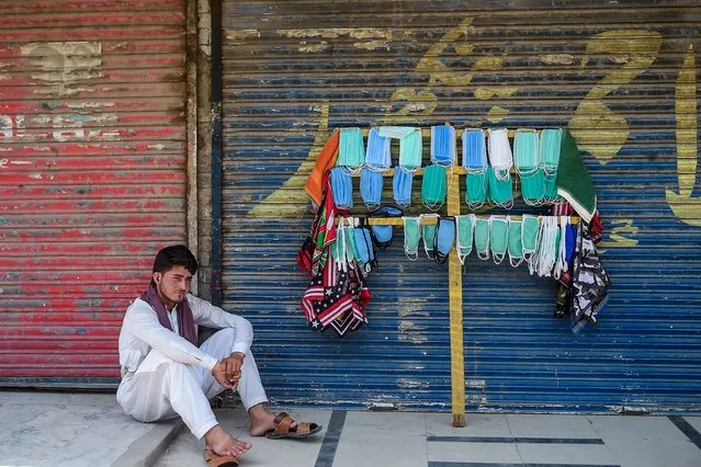 A street vendor selling facemasks sits as he waits for customers on a street in Rawalpindi on July 5, 2020. (Photo by Farooq Naeem/AFP Photo)