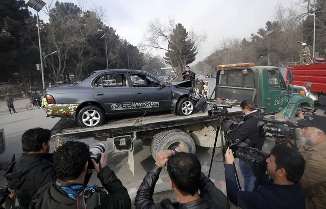 Afghan security officials remove a damaged vehicle from the scene of a suicide bomb attack in Kabul, Afghanistan, 25 December 2017. At least three people were killed in a suicide attack at the National Directorate of Security (NDS) office in Kabul. (Photo by Hedayatullah Amid/EPA/EFE)