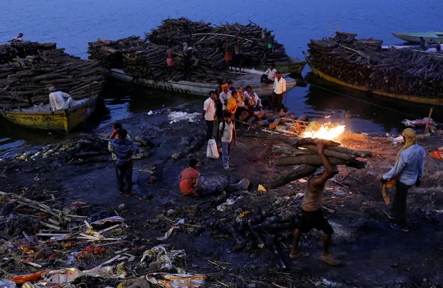 People watch as pyres burn at a cremation ground on the banks of the Ganges River in Varanasi, India April 7, 2017. (Photo by Danish Siddiqui/Reuters)