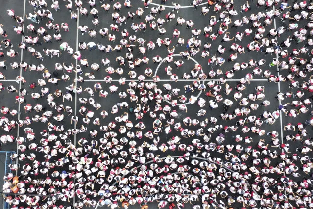 In this aerial view people participate in the second Aerobics Marathon with live Salsa music in Cali, Colombia, on December 14, 2022. (Photo by Joaquin Sarmiento/AFP Photo)