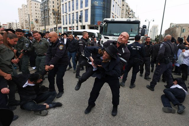 A protester is detained as Ultra-Ortodox Jewish men protest against attempts to change government policy that grants ultra-Orthodox Jews exemptions from military conscription in Jerusalem on February 26, 2024. (Photo by Ronen Zvulun/Reuters)