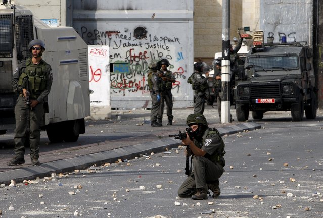 An Israeli border policeman aims his weapon at Palestinians during clashes in the occupied West Bank city of Bethlehem October 6, 2015. (Photo by Mussa Qawasma/Reuters)